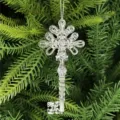 Macro detail of transparent acrylic Christmas key ornament hanging on green pine branch. - Retro Key Style / Clear