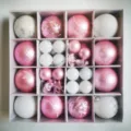 Overhead view of various pink and white Christmas ornament balls set in a grid gift box. - 44 Pieces / Pink Silver