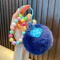 Cute dark blue plush pom-pom keychain with colorful iridescent beads and heart tag - Navy Blue (Random Beads Tag)
