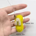 Close-up detail of handmade yellow pipe cleaner flip-flop keychain with pearl accents - Yellow