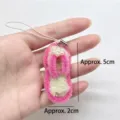 Close-up of handmade pink and white pipe cleaner flip-flop keychain with 5cm size mark. - Pink