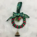 Detailed view of a festive red and green bell wreath with Happy Christmas ribbon - Diameter approx 12cm / Red and Green