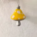 Close-up of yellow painted mushroom hanging ornament with white spots for Christmas - Yellow
