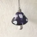 Close-up of a purple painted mushroom ornament with white polka dots for Christmas - Dark Blue