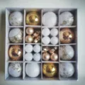 Close-up view of 44pcs white and gold Christmas bauble set in a square grid gift box - 44 Pieces / Platinum