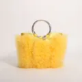 Detail of yellow ruffled tulle handbag featuring metallic silver ring handle and pleats. - Yellow