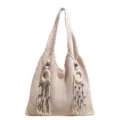 Gestrickte Schultertasche in Beige mit Holzringen und Quasten mit bösem Blick - Weiß
