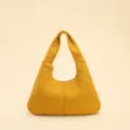 Close-up detail of a bright yellow crescent hobo bag featuring unique quilted stitching. - Yellow