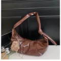 Brown glossy hobo shoulder bag with knotted strap and cute plush dog charm, stylish casual. - With Charm / Brown
