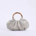 Detailopname van de retro geplooide stoffen handtas met een natuurlijk bamboe handvat. - Teal Blauw