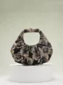 Dettaglio macro di borsa a mano plissettata in jacquard floreale vintage nero e oro - Nero