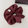 Primer plano de un coletero burdeos con etiqueta hecha a mano y textura de tela - Rojo