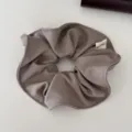 Primer plano de un coletero gris de tela acanalada con etiqueta Hand Made - Caqui
