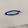 Detalle de un pasador de pelo BB azul con circonita roja y perla en fondo neutro - Clip BB / Azul zafiro