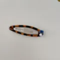 Detalle de un pasador de carey con una piedra de circón azul y una perla blanca elegante. - Clip BB / Estampado de leopardo