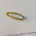 Detalle de pasador de pelo dorado con circonita azul cuadrada y una perla blanca redonda. - Clip BB / Amarillo