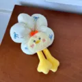 Detailed view of a cute plush duck flower hair scrunchie displayed on a wooden surface - Beige Duck Scrunchie
