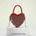 Red heart-shaped crossbody bag for women with double-sided metal rivets and chain tassel decor. - Dark Red
