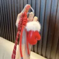 Portachiavi a guanto in pelle rossa con bordo in peluche bianco e corda intrecciata. - Rosso