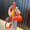 Sports theme keychain with basketball and golf club charms on sturdy orange cord - Orange