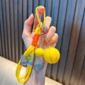 Yellow basketball and golf club themed sports keychain charm for bags and car keys. - Yellow