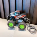 Cartoon off-road vehicle keychain featuring camouflage pattern and bright green wheels - Black