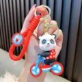 Cartoon panda riding bicycle keychain with red braided silicone strap - Red