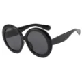 Occhiali da sole rotondi rétro oversize con montatura nera spessa e lenti scure. - Nero Lucido/Lente Grigia