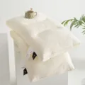 Detail shot of premium latex pillows featuring elegant 3D embroidery and silk labels - Crown Style / 1 Piece / Off White