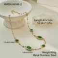 Detail of a gold stainless steel necklace with oval green zircon stones on white prop. - 18K Gold / Green (NMSN-M348-2)