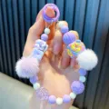 Dragonne de téléphone perlée violette faite main avec pompons et breloque donut - Pompon Violet