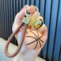 Portachiavi basket sportivo con cinturino intrecciato marrone e ciondolo a campana d'oro - Marrone