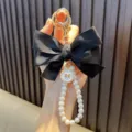 Handmade elegant black silk bow keychain featuring a stylish white pearl bead strap for bags - Black