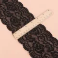 Detailansicht der Breitenmessung einer schwarzen elastischen Blumenspitze mit Holzlineal. - Elastische Spitzenborte Breite 10cm / 2 Yards / Schwarz
