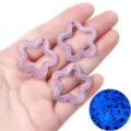 Close-up of glow-in-the-dark purple star pendants with glitter for DIY jewelry making. - 10 Pieces/Pack (Approx 30x30mm) / Luminous Purple