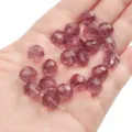 10mm purple faceted crystal glass beads displayed on a palm for DIY handmade jewelry - Round Beads / 10mm Approx 42 Pcs / Fuschia
