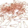 Vista dettagliata di numerose spille di sicurezza a bulbo in oro rosa per maglieria e tag - Oro rosa