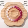 Handgefertigtes UV-farbwechselndes Harzperlenarmband auf einem dekorativen Holztablett. - Rose Glitzer UV Wechsel Mondstein (BSB154)