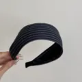 Vue détaillée de la texture du tissu rayé bleu marine sur ce bandeau à larges bords élégant - Serre-tête Rayé Noir