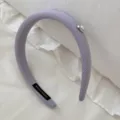 Close-up of lavender ribbed fabric headband with heart pearl and handmade tag details. - Purple