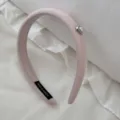 Close-up detail of a minimalist pink ribbed headband featuring a dainty heart pearl accent - Pink