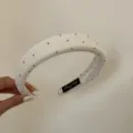 Dettaglio ravvicinato di un cerchietto bianco rétro a pois con imbottitura - Versione Larga (FG89012) / Pois Beige