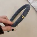 Luxe grijze gebreide haarband met een verfijnd gouden strikje voor dames mode accessoire - Gouden Tag Strik / Grijs