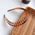 Macro detail of high-toughness amber plastic hair comb headband with long teeth - Brown