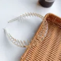 Detailed view of transparent toothed headband for hair styling on rattan tray - Champagne