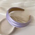 Detail view of lavender satin padded headband with subtle sheen on textured background - Shiny Silk Headband / Purple