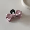 Primo piano di un elegante fermaglio per capelli a fiocco in raso rosa su bianco - Molletta per Capelli a Fiocco (7#) / Rosa