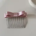 Vista dettagliata di un dolce pettine per capelli con doppio fiocco in nastro rosa - Pettinino Fiocco (8#) / Rosa