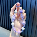Handmade purple beaded phone strap featuring iridescent rabbit and star charm decor - Purple