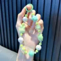 Handmade beaded phone strap featuring a cute green rabbit pendant and iridescent beads - Green